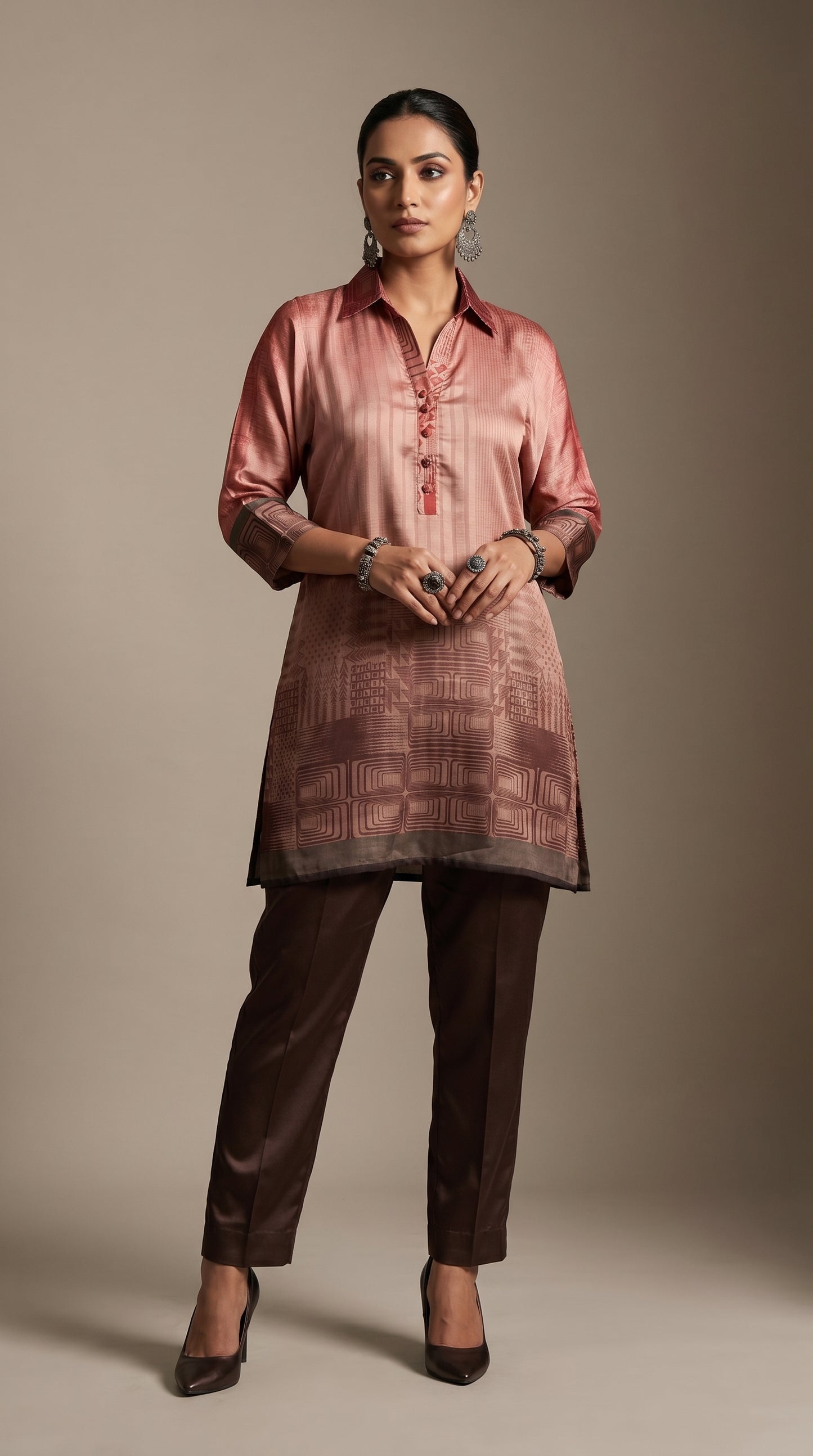 Woman wearing a pink kurta with brown pants against a beige background