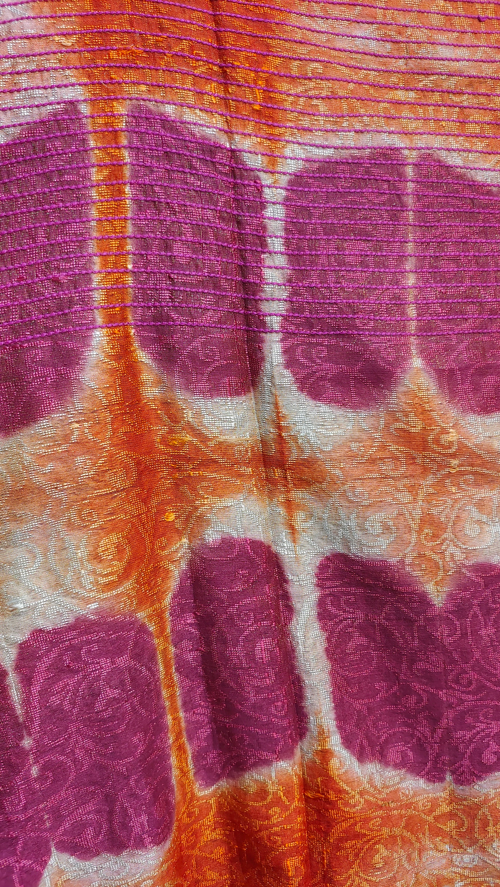 Close-up of fabric with purple shibori pattern on an orange background