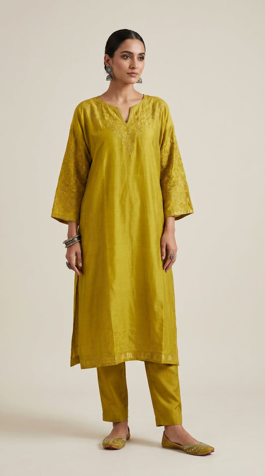 Woman wearing a mustard yellow kurta with pants on a beige background