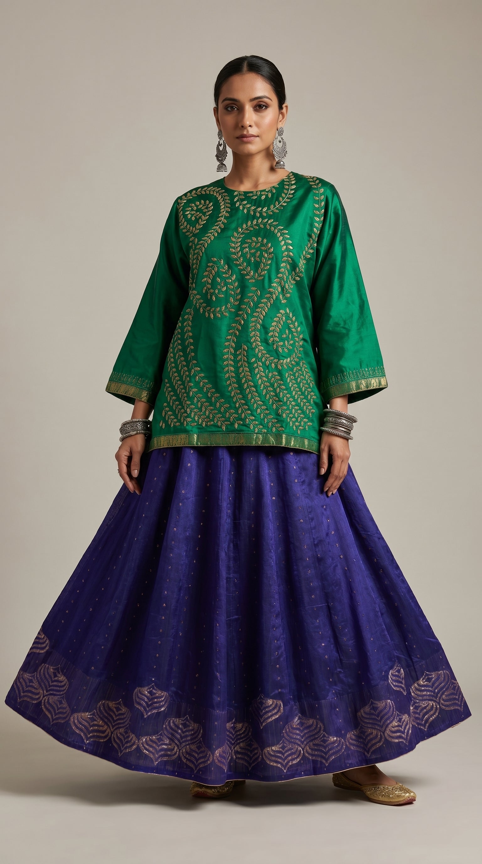 Woman wearing a green embroidered top and purple skirt on a beige background