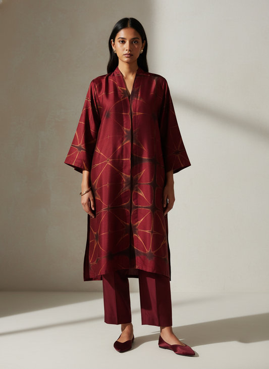 Woman wearing a maroon patterned kurta against a neutral background