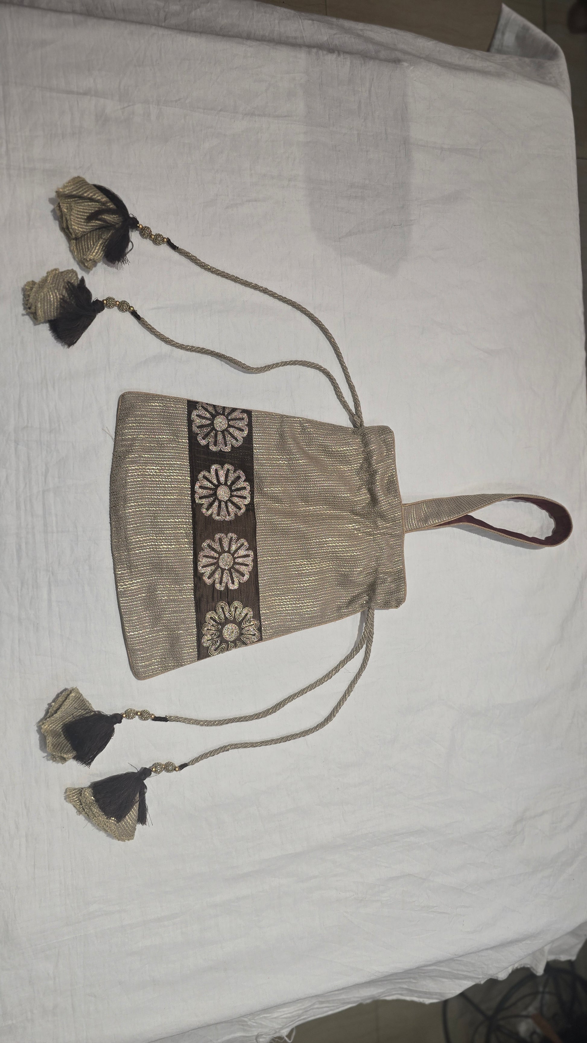 Textile beige handbag with decorative elements on a white background