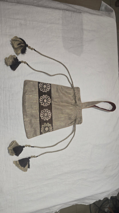Textile beige handbag with decorative elements on a white background