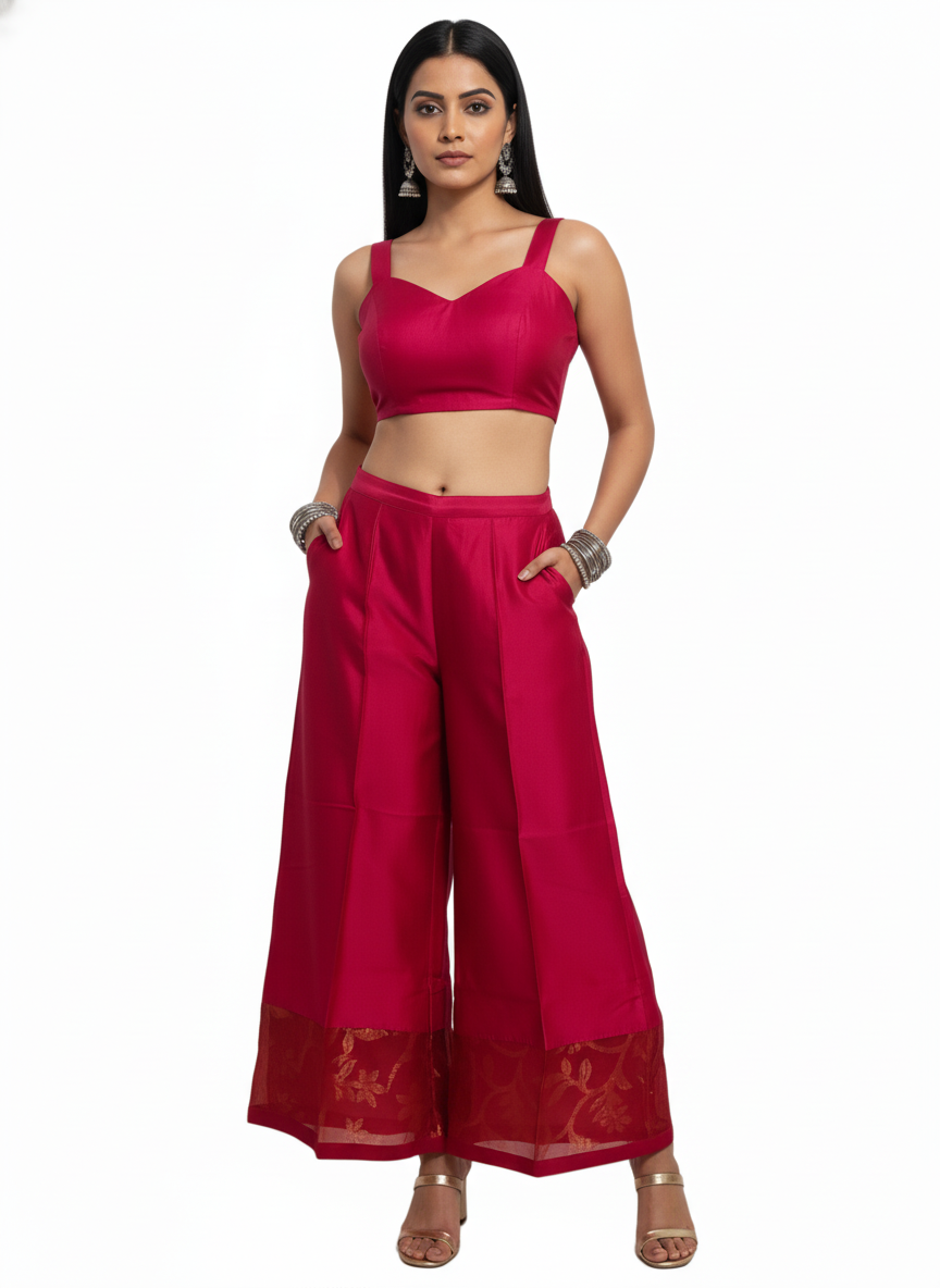Woman wearing a pink plazoo with a matching top on a white background